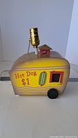 Side view of hot dog lamp showing detail on cart side with $1 hot dog graphic and light socket on top.