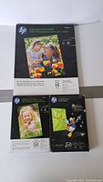 Displays one pack of HP Everyday Photo Paper 8.5x11 inch 50 sheets semigloss and two packs of HP 4x6 inch photo paper - one semigloss and one glossy.