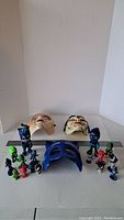 Photo showing full collection of PJ Masks small figurines and three masks on white surface.