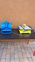 Blue B-Air air mover fan with handle and vent on a black table next to tile cutter.