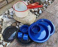 Full set of 10 enamelware items including pots, trays, plates, cups, and bowl arranged on stone surface.