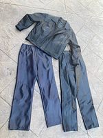 Overall photo showing women's black leather jacket and two pairs of leather pants: one black and one purple-black hue.