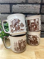 Four vintage Hollie Hobbie stoneware mugs with brown illustrations arranged stacked and side-by-side on wood surface with cement block background.
