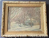 Frontal image of the framed oil painting showing a winter street scene with snow-covered trees and houses, signed bottom right.