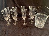 All 8 crystal flutes and the ice bucket on a dark background.