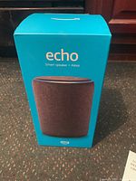 Box front showing the Amazon Echo 3rd Gen smart speaker image, in blue packaging with 'echo Smart speaker + Alexa' text.