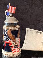 Full view of the America the Beautiful limited edition beer stein showcasing the patriotic eagle and flag design, US state shield, and lid with American flag sculpture.