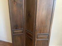 Close-up side view of the wood panels and two-way hinges showing wood grain and panel design details.