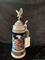 Full view of the Thewalt German beer stein showing detailed eagle relief on the body, colors, and pewter lid with eagle figurine.