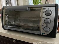Front view of Black & Decker toaster oven showing glass door, control knobs, and overall condition.