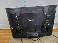 Rear view of a Viewsonic TV with cables and the attached mounting bracket.