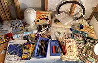 Overview of craft supplies showing colored pencils, sketch pad, paint brushes, scissors, and craft bags.