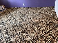 Full view of the large jungle print rug stretched out on the floor showing pattern and color.