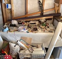 Overview of sewing and crafting materials arranged on a table with long wooden rulers and rolls of Velcro visible, various cutting and measuring tools, and fabric pieces in bins.