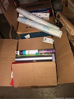 Open box showing several rolls of contact paper and heat transfer vinyl with partial packaging