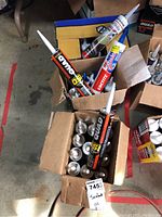 Box with various tubes of sealant including Quad OSI, Loctite, and Rustoleum Wet Patch.