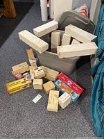 Image showing several white storage boxes and smaller labeled boxes spread out on floor next to a bin.