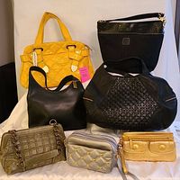 Seven ladies purses displayed together showing various styles, colors, materials, and brands