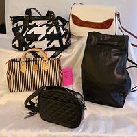 Five ladies purses displayed on white surface showing different styles and colors including quilted and patterned leather bags