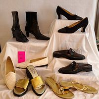 Six pairs of ladies shoes displayed on fabric backdrop showing variety of styles and colors including boots, pumps, flats, slides, and sandals.