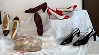 All five pairs of women's shoes displayed on white fabric background showing various angles and sides.