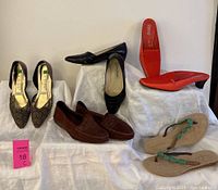 Photo of the lot showing multiple pairs of women's shoes including leopard print heels, black leather pumps, suede loafers, coral red slides, and flip-flops.