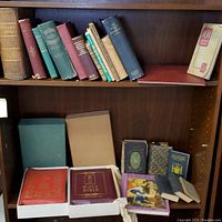 Overall view of shelves with assortment of old books, mostly hardcovers, including Bibles and other subject matter books in varied conditions.