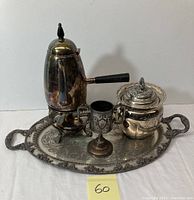 Full set of silverplate serviceware with coffee pot, tray, chalice, and covered jar shown together.