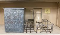 Full lot showing galvanized metal milk box, metal delivery rack, and two stoneware milk bottles.