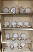 Overall display of porcelain coffee and dining service on shelving