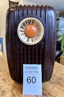 Front view in upright orientation showing ribbed grill and illuminated AM tuning dial