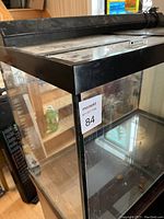 Close-up of top corner of the aquarium showing the black frame and top cover with light fixture.