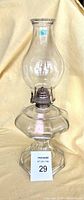 Full view of the antique pressed glass hurricane oil lamp showing the octagon shaped base, button detail on the stem, and clear glass chimney.