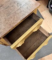 Top angled view showing opened drawers with dovetail joints and carving detail on handles.