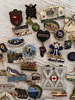 Close up of various enamel Lions Club pins from Canadian towns and districts including Widdifield, Bedford, Jordan, and Napanee.