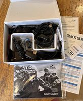 Box containing various components of Cardo Scala Rider G9 power set including communication headsets, cables, and user manuals.