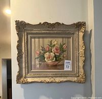 Front view of framed oil painting featuring roses in a pink bowl, showing the ornate plaster frame and signature on the painting.