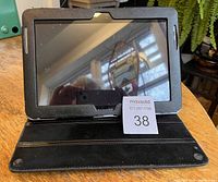 Front view of Samsung Galaxy Tab 2 10.1 tablet in black protective case showing screen and brand logo.