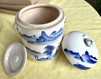 Front and side view of the tea caddy with lid removed showing blue hand-painted landscape scene on white ceramic