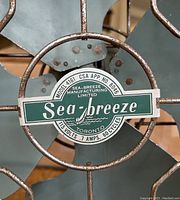 Close-up of fan blade center showing Sea-Breeze brand label with technical details.