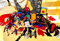 Various Spider-Man action figures and assorted Spider-Man toys spread on a surface including Green Goblin figure and accessories.
