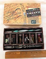 Original boxed writing set showing two blown glass pens and six ink bottles fitted in compartments.