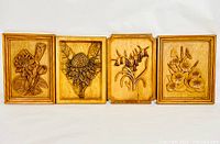 Four rectangular wood panels with carved floral reliefs, arranged side by side, showing entire set.