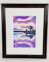 Framed watercolour painting depicting a reflective lake scene with purple and yellow sky, silhouetted trees, matted and under glass in a dark wooden frame.