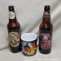 Front view of two Iron Maiden themed beer bottles and one Iron Maiden mug showing front labels and artwork.