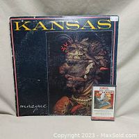 Photo of Kansas 'Masque' vinyl LP album cover and 'The Best of Kansas' cassette tape beside it, showing front artwork and size comparison.