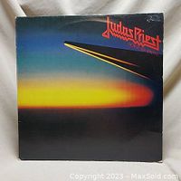 Front cover of Judas Priest Point of Entry vinyl LP showing colorful gradient design and band logo.
