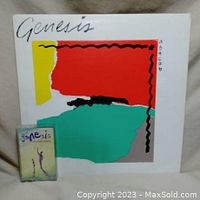 Photo of Genesis 'Abacab' vinyl album cover and a separate cassette tape album in front, showing cover art and album title.