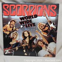 Front cover of the Scorpions 'World Wide Live' double vinyl album showing the band members performing on stage with bold red album title.