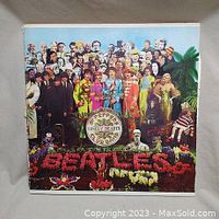 Front cover of the Sgt. Pepper's Lonely Hearts Club Band vinyl album showing the iconic group collage and floral lettering.